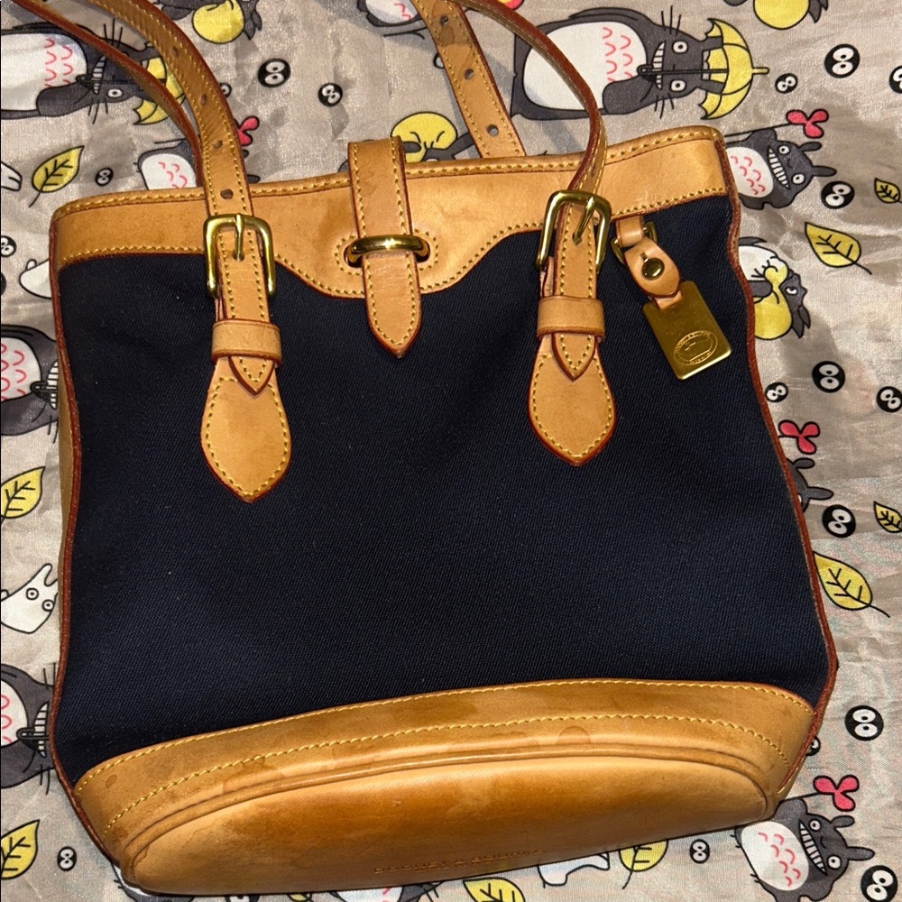 A vintage Dooney & Bourke Cabriolet bucket bag in navy canvas with tan leather
